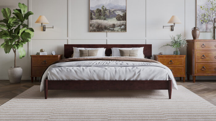 Dark wood low-profile bed styled with neutral bedding and coordinated wood furniture.